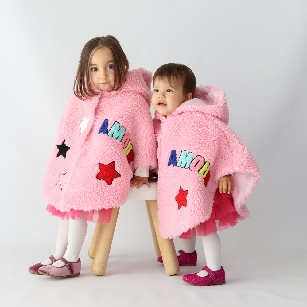 bambine di 18 mesi e 12 mesi che indossano la mantellina teddy rosa in calda pelliccia